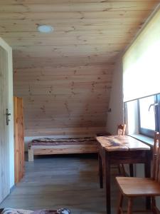 a room with a bed and a wooden ceiling at zajęcza chata in Dolistowo