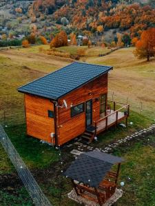 een tiny house met een zonnedak op een heuvel bij Roua by NorAtlas Heritage - Adults Only in Buzău