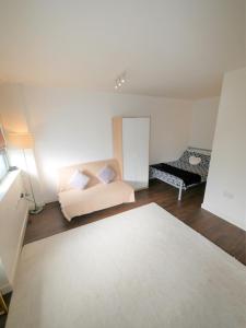 a white room with a bed and a white rug at Hill House Holiday Apartments in Bournemouth