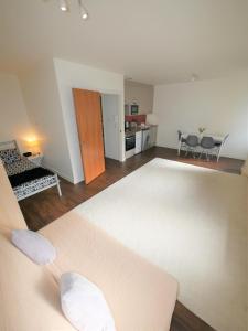a living room with a large bed and a kitchen at Hill House Holiday Apartments in Bournemouth