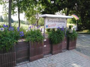 un cartel en una valla con flores y plantas en Ferienwohnung Kiruga en Kippenheim