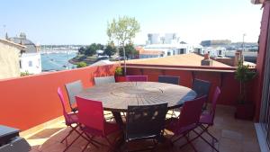 een tafel en stoelen op een balkon met uitzicht bij Villa du Quai in Les Sables-dʼOlonne