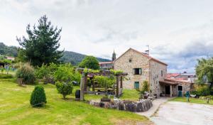 a stone house with a garden in front of a building at Casa da Roncha in Noya