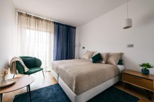 een slaapkamer met een bed, een stoel en een raam bij Funchal BEAUTIFUL vista mar in Funchal +36 foto's