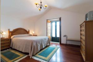 a bedroom with a bed and a dresser and a window at Casa da Roncha in Noya