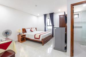 a bedroom with a bed and a tv in it at Bao Ngoc Hotel & Apt in Danang