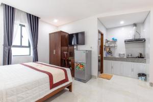 a bedroom with a large bed and a kitchen at Bao Ngoc Hotel & Apt in Danang