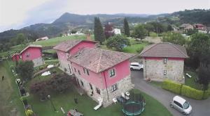 una vista aérea de una gran casa de color rosa en Apartamentos La Quintana de Romillo, en Romillo