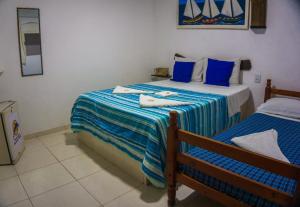 ピパにあるPousada Sonho Meuのベッドルーム1室(青と白のシーツが備わるベッド2台付)