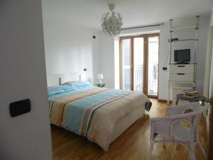A Casa di Monica في بوتسولي: غرفة نوم بيضاء مع سرير وتلفزيون