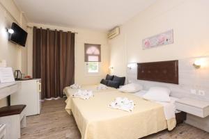 a hotel room with two beds and a television at Summer Beach Hotel in Polychrono