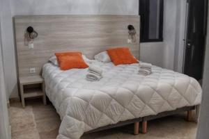 a large white bed with orange pillows on it at A PIANARELLA in San-Gavino-di-Carbini