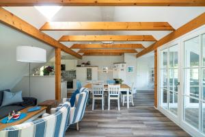 a dining room and living room with wooden ceilings at Strandhaus Düne 19 - Gelassenheit in Neuhaus