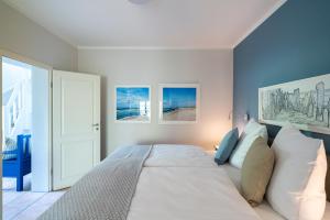 a bedroom with a large bed with white pillows at Strandhaus Düne 19 - Gelassenheit in Neuhaus