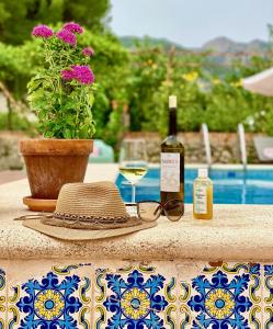 een hoed en een bril op een tafel met een fles wijn bij Casa de Los Lirios in Muro de Alcoy