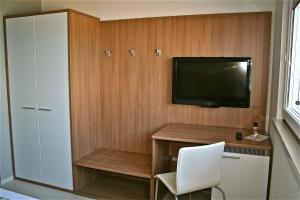 a room with a tv and a desk with a chair at Hotel Baia Marina in Cupra Marittima