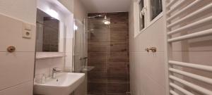 a white bathroom with a sink and a shower at Ermis Apartments in Metzingen +53 photos