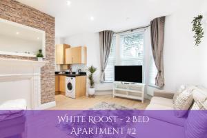 a living room with a white root bed apartment at The Roost Group - Bedford House Apartments in Gravesend