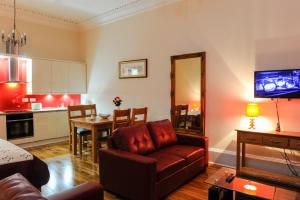 a living room with a couch and a dining room at Edinburgh City Suites in Edinburgh
