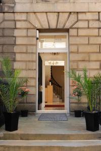 an entrance to a building with potted plants at Edinburgh City Suites in Edinburgh