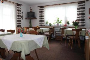 a dining room with tables and chairs and windows at Haus Heimattreu in Schönau am Königssee