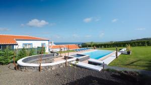 een huis met een zwembad in een tuin bij Quinta Rico in Quatro Ribeiras
