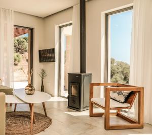 a living room with a stove and a table and chairs at Skiathos Symbol Villas in Achladies
