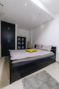 a bedroom with a large bed with a yellow pillow at Apartments Luka in Kragujevac