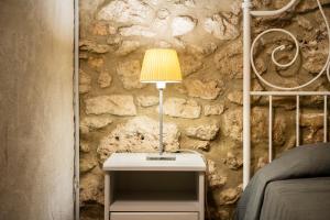 a table with a lamp on it next to a stone wall at Casa rural ideal para familias y amigos in Serinyà