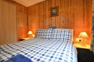 BenmoreにあるAsh Lodgeのベッドルーム(青と白のチェッカーベッド付)