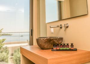 a bathroom with a bowl on a counter with a sink at Skiathos Symbol Villas in Achladies