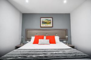 a bedroom with a large bed with red pillows at Belmont Llandudno in Llandudno