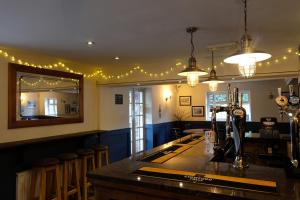 a bar with a mirror and a counter with stools at The Lawns Hotel in Derby