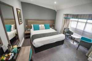 a bedroom with a bed and a desk and a window at Belmont Llandudno in Llandudno