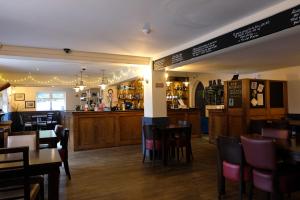 a restaurant with wooden tables and chairs and a bar at The Lawns Hotel in Derby