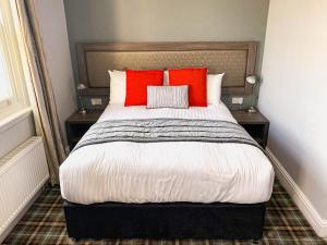 a bedroom with a large bed with red pillows at Belmont Llandudno in Llandudno
