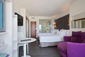 une chambre d'hôtel avec deux lits et un canapé dans l'établissement Meliá Palma Marina, à Palma de Majorque