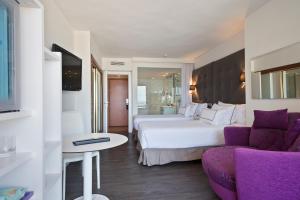 a hotel room with two beds and a couch at Meliá Palma Marina in Palma de Mallorca
