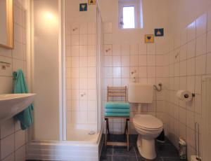 uma casa de banho com um WC, um chuveiro e um lavatório. em Napkorong Vendégház Feked em Feked