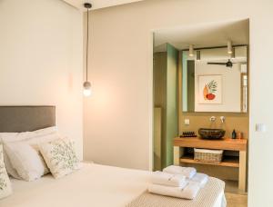 a bedroom with a bed with a mirror and a sink at Skiathos Symbol Villas in Achladies