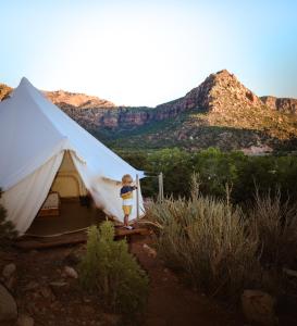 a young boy standing in front of a tent at Zion Glamping Adventures in Hildale