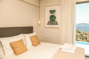a bedroom with a bed and a large window at Skiathos Symbol Villas in Achladies