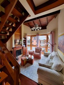 ein Wohnzimmer mit Sofa und Kamin in der Unterkunft Duplex aconchegante no Buganvilias Flat in Gramado