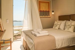 une chambre avec un lit avec des serviettes dessus dans l'établissement Skiathos Symbol Villas, à Achladies 31 autres photos