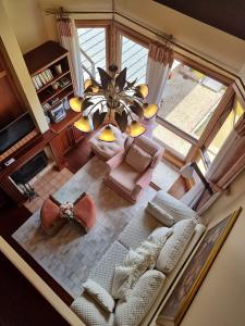 einen Blick über ein Wohnzimmer mit einem Kronleuchter in der Unterkunft Duplex aconchegante no Buganvilias Flat in Gramado + 27 Fotos