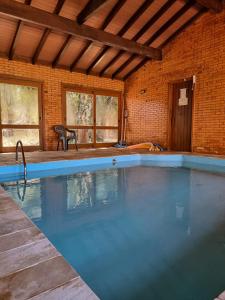 ein großer Pool in einem Backsteingebäude in der Unterkunft Duplex aconchegante no Buganvilias Flat in Gramado