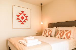 a bedroom with a bed with towels on it at Skiathos Symbol Villas in Achladies