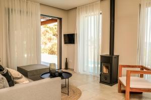 a living room with a fireplace and a couch at Skiathos Symbol Villas in Achladies