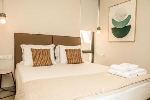 a bedroom with a bed with white sheets and pillows at Skiathos Symbol Villas in Achladies