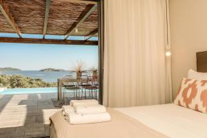 - une chambre avec un lit et une vue sur l'océan dans l'établissement Skiathos Symbol Villas, à Achladies
